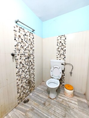 Habitación básica doble | Baño | Regadera, regadera tipo lluvia, pantuflas, toallas 