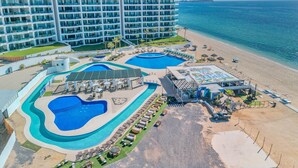 A resort with multiple swimming pools, a beach area, and a large hotel building. - Esmeralda Beach Resort 3 Bedrooms C 703 (Puerto Peñasco)