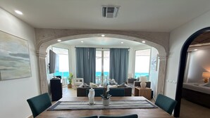 A dining area with a view of the sea, a large table, and chairs. - Esmeralda Beach Resort 3 Bedrooms C 703 (Puerto Peñasco)