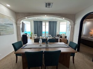 A dining area with a view of the sea, a large table, and chairs. - Esmeralda Beach Resort 3 Bedrooms C 703 (Puerto Peñasco)