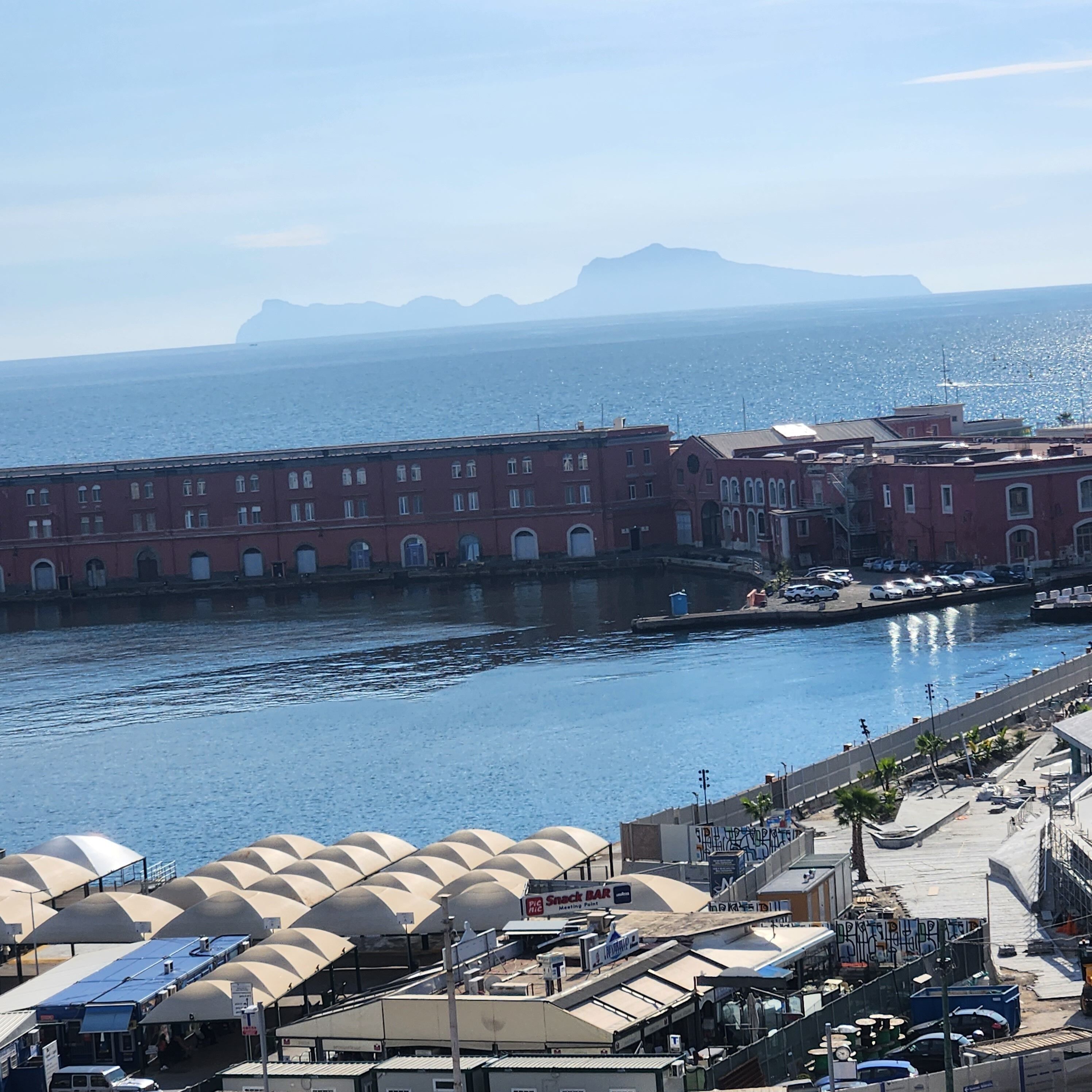Vista al agua con edificios, un puerto deportivo y cielo despejado.
