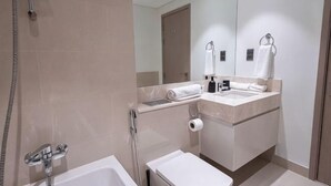 Un baño moderno con bañera, lavamanos y espejo.