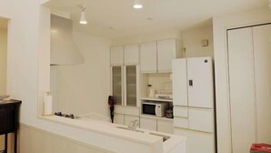 Una cocina moderna con armarios blancos, un microondas y un refrigerador.