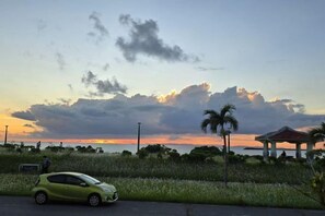 A sunset with clouds, a green car, and a gazebo. - 15 Minutes to Airport~1 Minute Walk to Beach YeHeJu (Itoman)