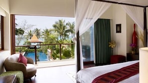 Ein Schlafzimmer mit großem Fenster, einem Bett, einem Sessel und einem Nachttisch.