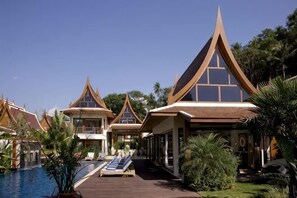 Un complexe hôtelier comprenant plusieurs bâtiments de style bungalow, une piscine et une promenade en bois.