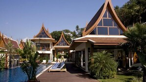 Ein Resort mit mehreren bungalowartigen Gebäuden, einem Schwimmbad und üppiger Bepflanzung.