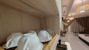 Habitación de hotel moderna con una pared de madera, un comedor con vajilla blanca y vista al área de estar.