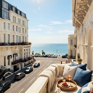 A balcony with a view of the sea, a wicker basket with strawberries, and a glass of drink. - Burlington Palace North Wing, Palatial Suites, Velvet Dining Room, (Eastbourne)
