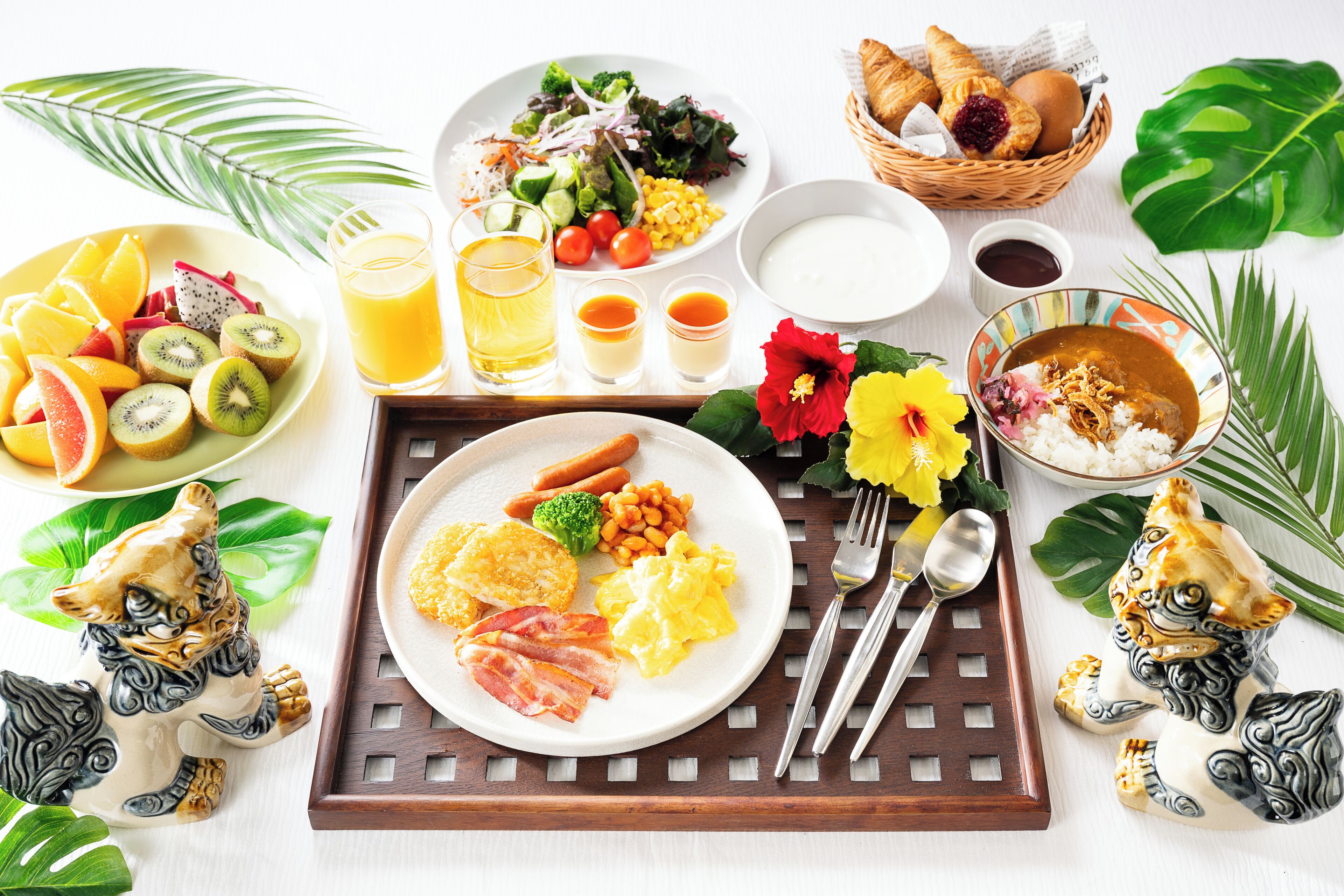 A breakfast buffet with various dishes, drinks, and decorative items.