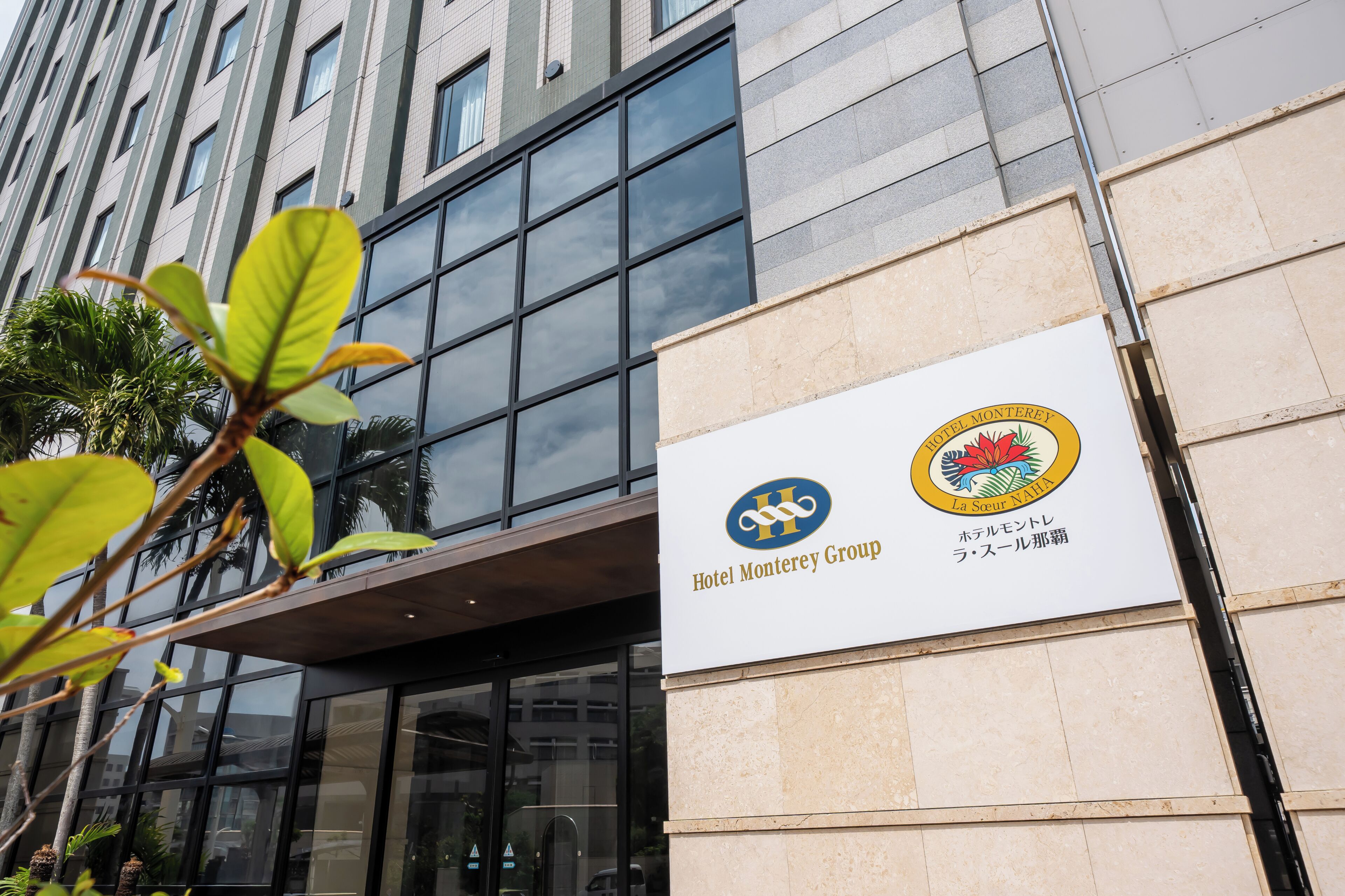 A building with a sign for Hotel Monterrey Group, featuring a logo and Japanese text.