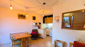 A compact living space with a dining area, kitchenette, and a small seating area. - Large studio cabin 4 pers. with garage 600m from ski lifts (Arêches-Beaufort)