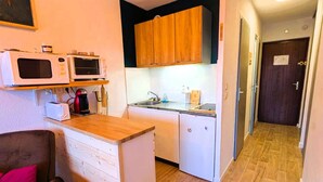 A compact kitchen with white cabinets, a wooden countertop, and a microwave. - Large studio cabin 4 pers. with garage 600m from ski lifts (Arêches-Beaufort)