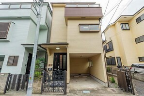 A residential building with a front entrance, a small porch, and a gated driveway. - 4-min walk/4 lines/95m2+free garage/4BR 2T 2B (Tokyo)