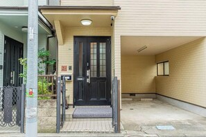 A building entrance with a black door, a small porch area, and a tiled ground. - 4-min walk/4 lines/95m2+free garage/4BR 2T 2B (Tokyo)