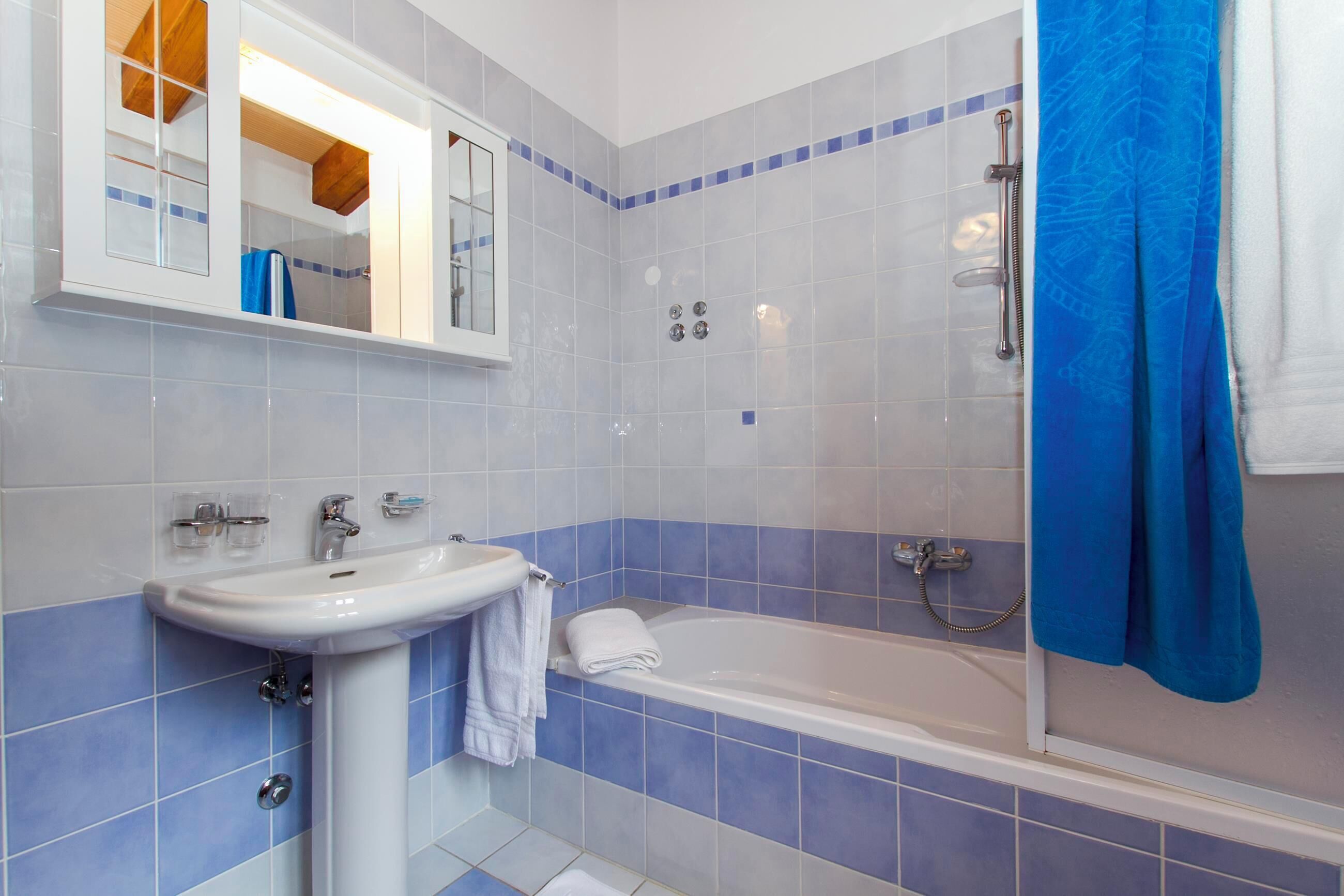 A bathroom with a white sink, a bathtub, and a shower.
