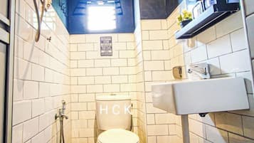Een compacte badkamer met toilet, wastafel en douche.
