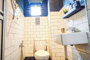 A compact bathroom with white tiles, a toilet, a shower, and a sink. - Lovely Garden Home BBQ Event at Klang by HCK (Klang District)
