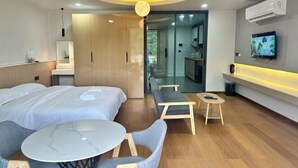 A modern hotel room with a bed, a small round table, two chairs, a TV, and a ceiling light. - Sokview Residence (Luang Prabang)