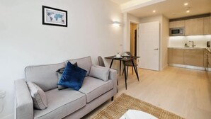 Een moderne woonkamer met een grijze bank, een klein tafeltje en een wereldkaart aan de muur.