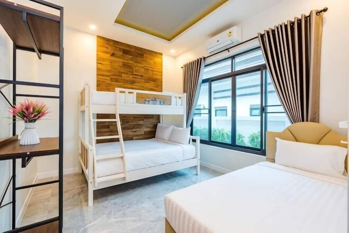 Ein Hotelzimmer mit Etagenbetten, einem großen Fenster, einer Holzwand und einem modernen Deckenstil.
