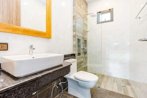 A bathroom with a white sink, toilet, and glass shower enclosure. - Me&You Pool Villa Hua Hin (Cha-am)