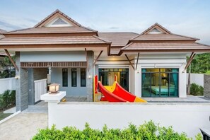 A modern house with a red slide, a covered patio, and a large window. - Me&You Pool Villa Hua Hin (Cha-am)