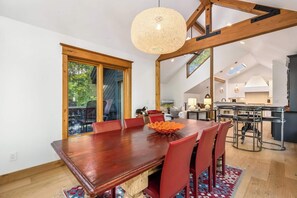 A dining area with a wooden table, red chairs, and a large decorative bowl. - Evergreen Escape – Home for 10 (Vail)