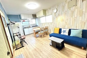 Een ruimtelijke zithoek met een eethoek, een bank en een kitchenette.