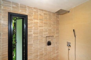A bathroom with a shower, a door with a frosted glass panel, and a wall-mounted light fixture. - patong hill 3 villa (Phuket)