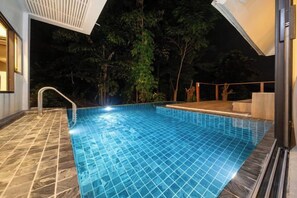 A swimming pool with a tiled edge, a metal ladder, and a wooden deck area. - patong hill 3 villa (Phuket)