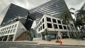A modern building with a unique angular design, large windows, and a paved area with potted plants. - Near MOA beside Okada Pet Friendly 1BR 3 pax WIFI 8T (Paranaque)