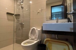 A bathroom with a glass-enclosed shower, a toilet, and a sink with a mirror above it. - Near MOA beside Okada Pet Friendly 1BR 3 pax WIFI 8T (Paranaque)