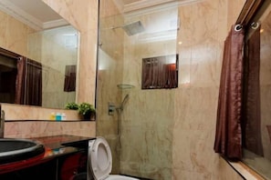 A bathroom with a glass-enclosed shower, a toilet, and a sink with a mirror above it. - Sunfit International Limited (Lagos)