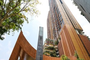 Un edificio alto con diseño moderno, que cuenta con fachada de vidrio y una estructura angular distintiva en la base.