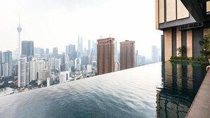 A modern building with a rooftop infinity pool overlooking a city skyline. - Lucentia Residence at Kuala Lumpur by Dreamcloud Sdn Bhd (Kuala Lumpur)