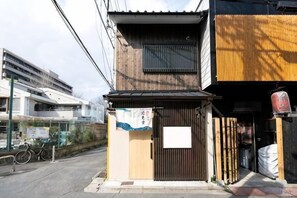 A small building with a wooden facade, a signboard, and a bicycle parked outside. - INN Plus Hanamidou (Kyoto)