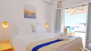 Een hotelkamer met een bed, nachtlampjes, een raam en uitzicht op buiten.