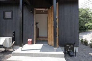 A hotel entrance with a wooden door, a signboard, and a small outdoor seating area. - [TV] Luxury adult secret base villa 120 ㎡ Sauna, stone bath, bonfire, BBQ [Mori building] (Miyota)