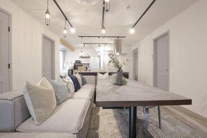A modern interior with a dining table, bench seating, pendant lighting, and a kitchen in the background. - [TV] Luxury adult secret base villa 120 ㎡ Sauna, stone bath, bonfire, BBQ [Mori building] (Miyota)