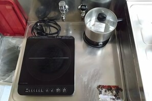 A kitchen with a stove, a kettle, and a sink. - Traditional Inn (Tokyo)