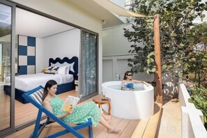 A modern hotel room with a bed, a reading area, and a hot tub. - Prime Beach House No. V7 (Sattahip)