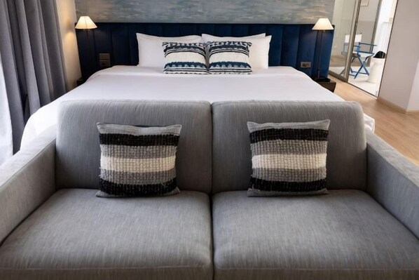 A bed with a headboard, two pillows, and two bedside tables with lamps.