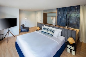 A hotel room with a large bed, a television, a desk, and a mirror. - Prime Beach House No. V7 (Sattahip)