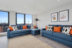 A modern living room with two sofas, a large window, and artwork on the wall. - Host & Stay The Baltic Penthouse 2 (Liverpool)