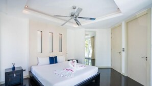 A modern hotel room with a bed, a ceiling fan, a nightstand, and a door. - Modern 5BR Party Gathering Pool Villa - VVP31.10 (Pattaya)