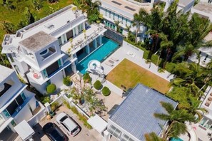 A modern multi-story building with a swimming pool, a covered patio, and a car parked in front. - Modern 5BR Party Gathering Pool Villa - VVP31.10 (Pattaya)