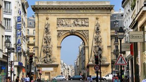 Un arco histórico con inscripciones 'LVDOVICO MAGNO' y 'BEHAP' en los edificios que lo flanquean.