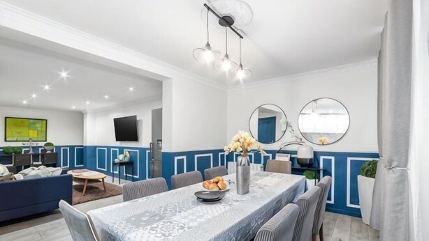 Un espace repas comprenant une table, des chaises et une décoration aux couleurs bleu et blanc.