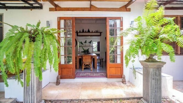 A traditional wooden door with glass panels, leading to an interior space with a table and chairs. - Hermoso Hideaway (Klaeng)